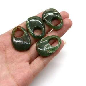 Macro detail of moss agate and tiger eye stone pendants with natural white textures