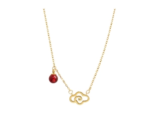 Detailed close-up of golden hollow cloud pendant with a red bead on minimalist necklace