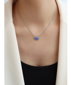 Nahaufnahme des blauen Evil Eye Anhängers an einer feinen Silberkette getragen am Hals