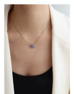 Detail der Evil Eye Halskette aus Roségold mit blauem Emaille-Anhänger am Frauenmodell