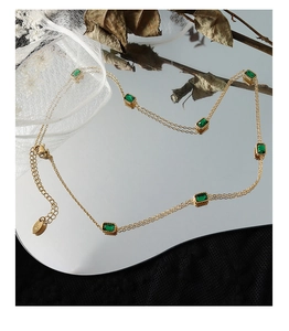 Vue macro d'un collier double couche en or 18 carats avec sept zircons vert émeraude