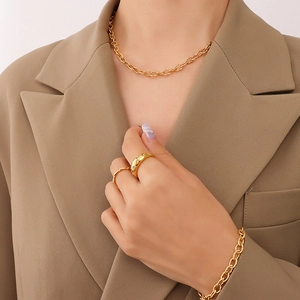 Golden chunky chain necklace and bracelet set with textured oval links on female model