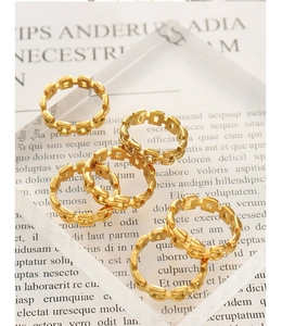 Macro shot of gold-plated chain link rings with hollow rectangular design for men and women