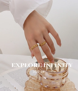 Close-up of gold chain link rings on fingers with minimalist jewelry aesthetic