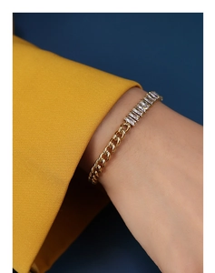 Close-up of gold plated Cuban chain bracelet with rectangular zircon stones on a model