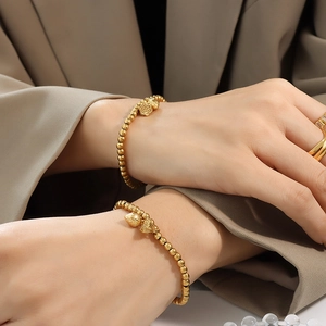 Golden beaded bracelet with lotus pendant and gemstone ring set for women