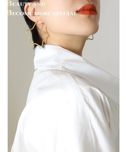 Close-up of golden hollow star earring worn by a model in a minimalist style