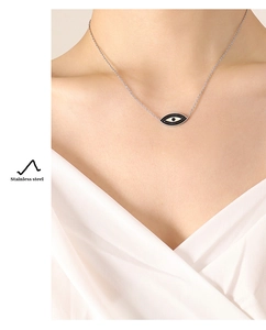 Dettaglio ravvicinato di una collana con ciondolo Evil Eye in acciaio inox su modella