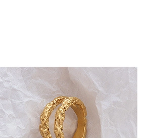 Close-up van gouden dubbellaagse ring met onregelmatige gehamerde textuur en retro ontwerp