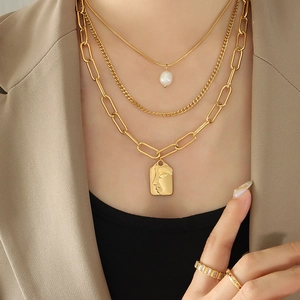 Gold-tone triple layered necklace with freshwater pearl and abstract face pendant