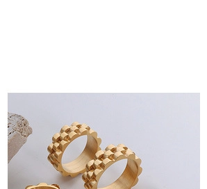 Detailansicht von zwei goldenen Titanringen mit modularer geometrischer Waffeltextur