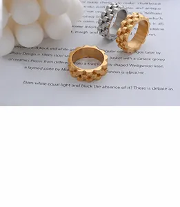 Primer plano detallado de anillos geométricos con textura en acabados oro y plata
