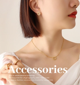 Nahaufnahme von Model mit goldenem Smiley-Schmuckset mit Halskette und Ohrringen getragen