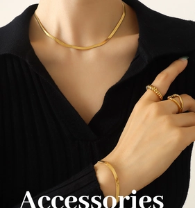 Close-up of 18K gold snake chain necklace, bracelet and ring set on female model