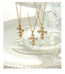 Vue détaillée de trois colliers croix dorés de style français avec perles élégantes