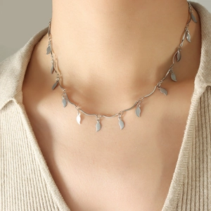 Collar de cadena ondulada plateada minimalista con colgantes de hojas en una modelo