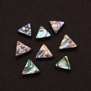 Close-up of polished triangle abalone shell beads with natural iridescent luster for DIY jewelry