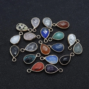 Close-up of assorted teardrop gemstone pendants with gold plating for jewelry making