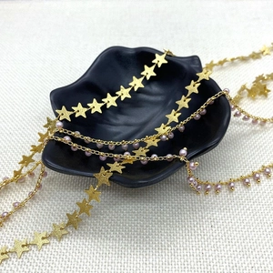 Detalle de cadena dorada con estrellas y perlas rosas para accesorios de joyería DIY