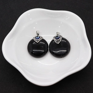 Detailed view of black onyx round pendant featuring a blue evil eye stone and silver clasp