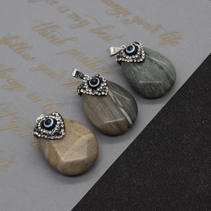 Macro shot of evil eye agate teardrop pendants with diamond-set metal clips