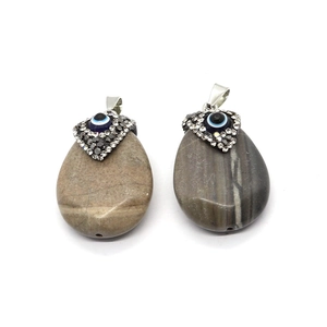 Natural agate teardrop pendants with evil eye crystals and silver pinch bails on white background