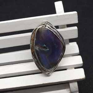 Detail of handcrafted wire-wrapped natural agate stone ring with purple mineral texture