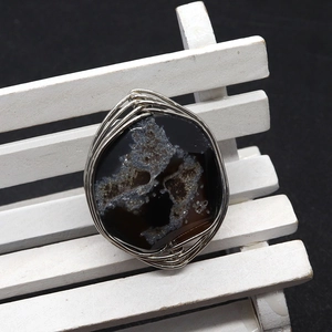 Handmade wire wrapped natural agate ring with dark druzy crystal on a miniature white bench