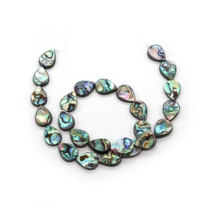 Iridescent abalone shell teardrop beads arranged in a spiral for DIY jewelry making