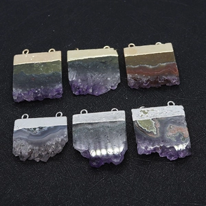 Detailed macro view of natural amethyst slice pendants with dual gold and silver plated loops