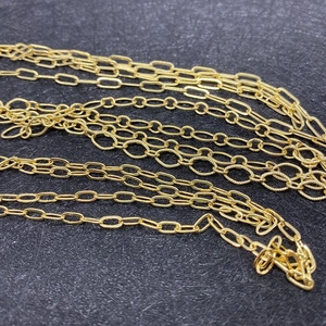 Macro view of assorted golden copper oval link chains for DIY jewelry making