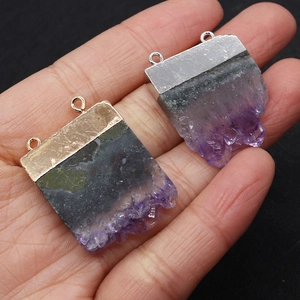 Macro shot of natural amethyst stone pendants with gold and silver plated connectors
