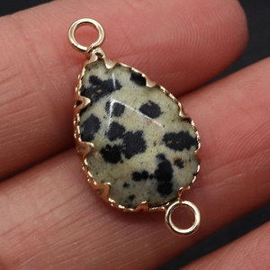 Macro-opname van gefacetteerde natuursteen connector met twee gouden lussen voor DIY-sieraden