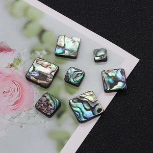 Macro shot of square abalone shell beads with natural iridescent colors for DIY jewelry