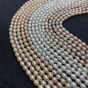 Macro detail of natural rice-shaped freshwater pearls in white, gold, and purple colors