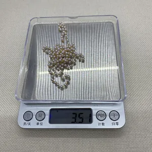 Detailopname van een 3,51g goudkleurige ketting met witte faux parels van 3-8mm
