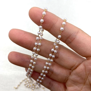 Gouden gedraaide ketting met 3mm-8mm witte parels op beige getextureerde stof