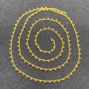 Detailed close-up of 2mm golden ball chain link with polished finish for DIY jewelry