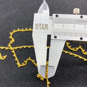Precision measurement of a 2mm gold bead on a twisted chain using a vernier caliper