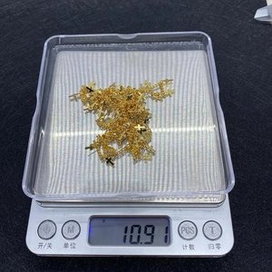 Primo piano di collane con croce dorata su bilancia digitale per pesatura precisa
