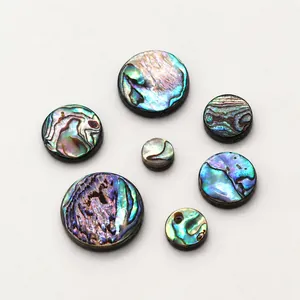 Macro detail of round natural abalone shell flat beads with colorful iridescent textures