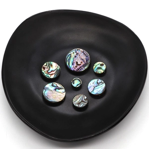 Natural round abalone shell beads set with iridescent texture in a black tray
