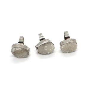 Three natural white druzy quartz oval rings with silver-plated frames on white background