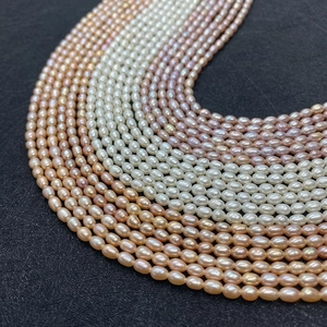 Macro detail of natural freshwater rice pearls in assorted colors on a black background