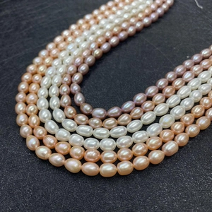 Macro shot of colorful rice-shaped freshwater pearls in white, pink, and purple shades