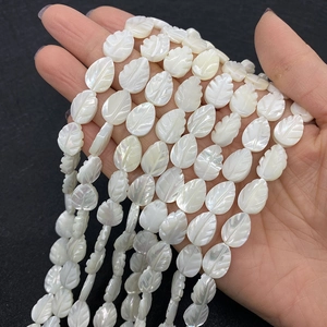 Detail van bladvormige witte schelp kralen met gegraveerde nerven voor DIY sieraden maken