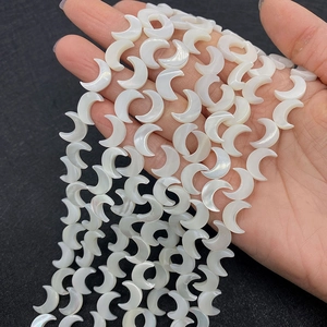 Makroaufnahme von weißen schillernden Muschelperlen in Mondform für DIY-Schmuck