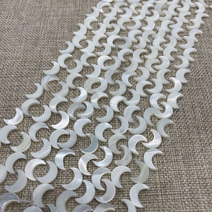 Makroaufnahme von natürlichen weißen Muschelperlen in Mondform für DIY-Schmuckherstellung