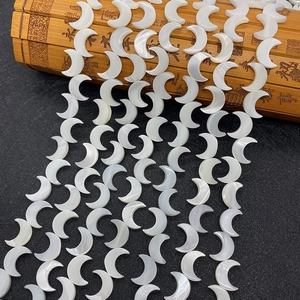 Makro-Detail weißer mondförmiger Muschelperlen mit natürlichem Perlmuttglanz für DIY-Schmuck