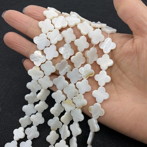 Macro detail of white mother of pearl clover beads for DIY jewelry making with shiny finish